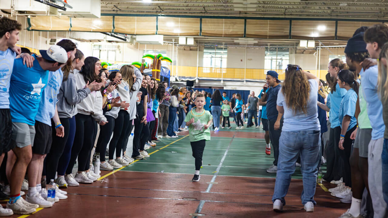 Miracle child walks through crowd of cheering students