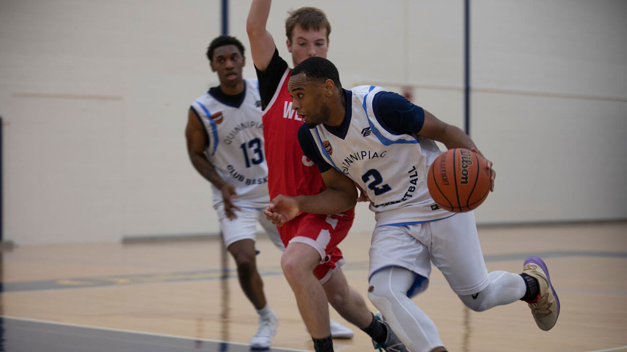 Running down court with basketball