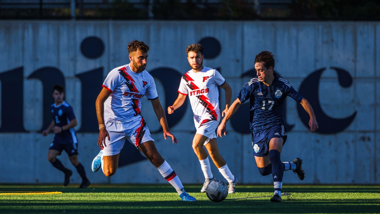 Men running after soccer ball