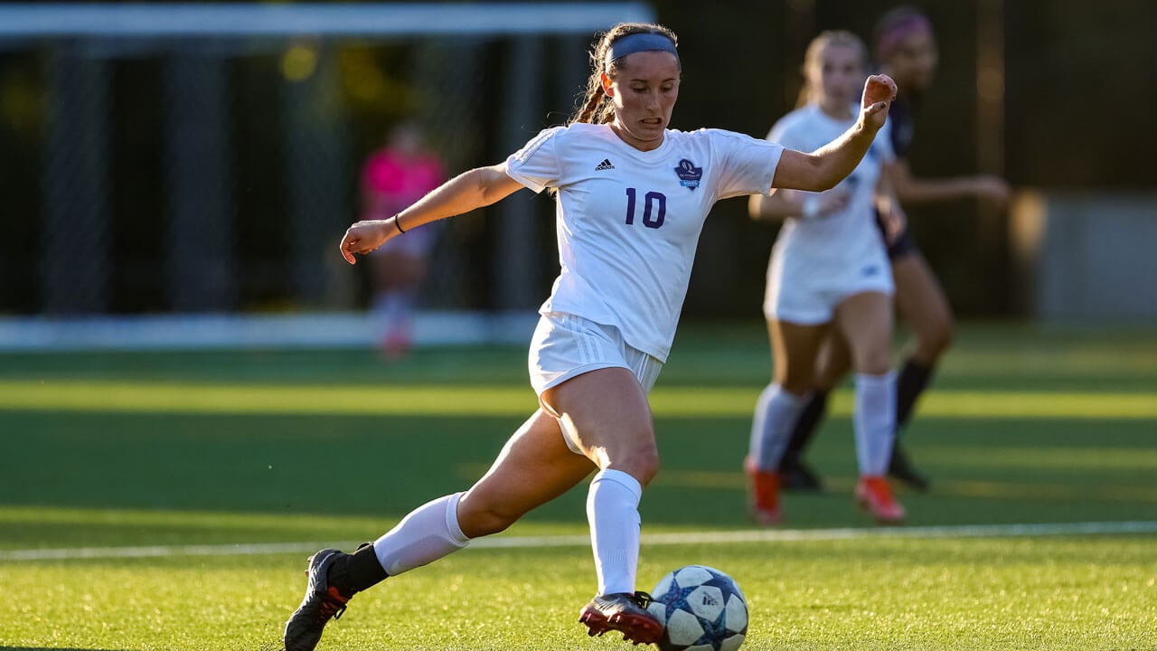 Woman kicking soccer ball