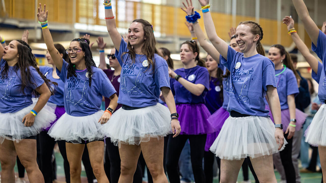 Student organization members stand together, smiling and enjoying QTHON activities