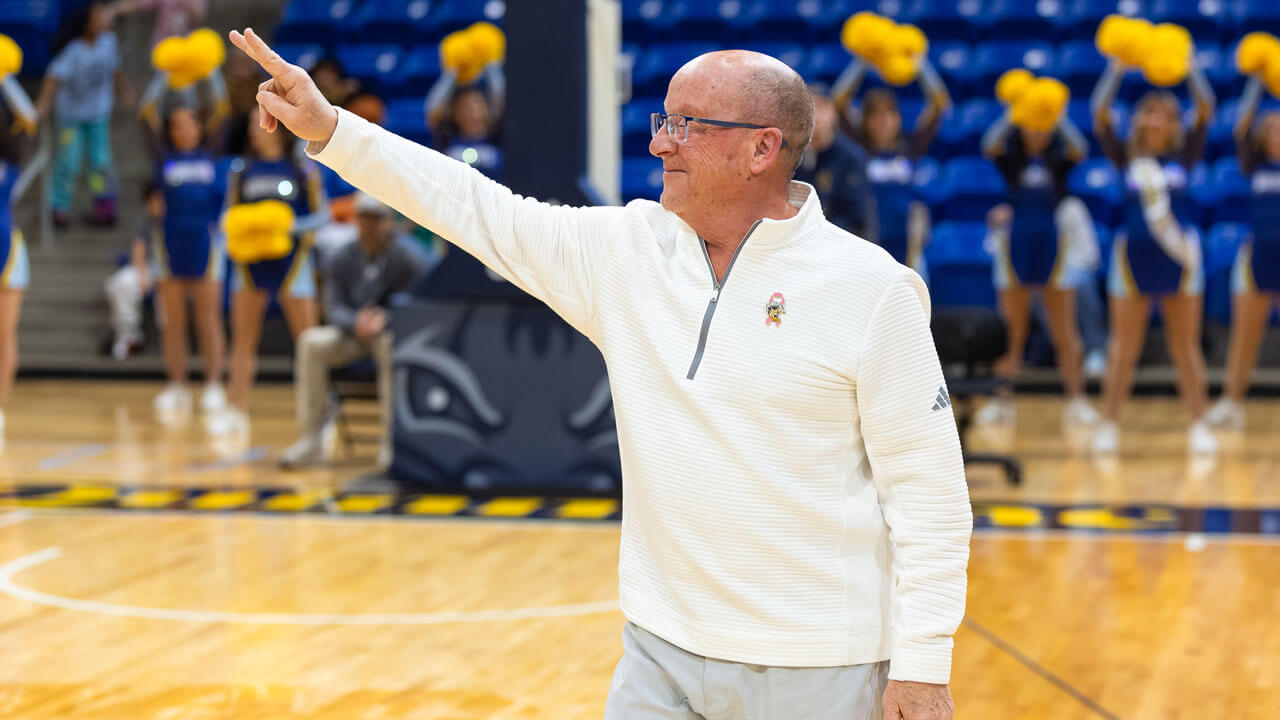 Man standing on the basketball court holding up a peace sign