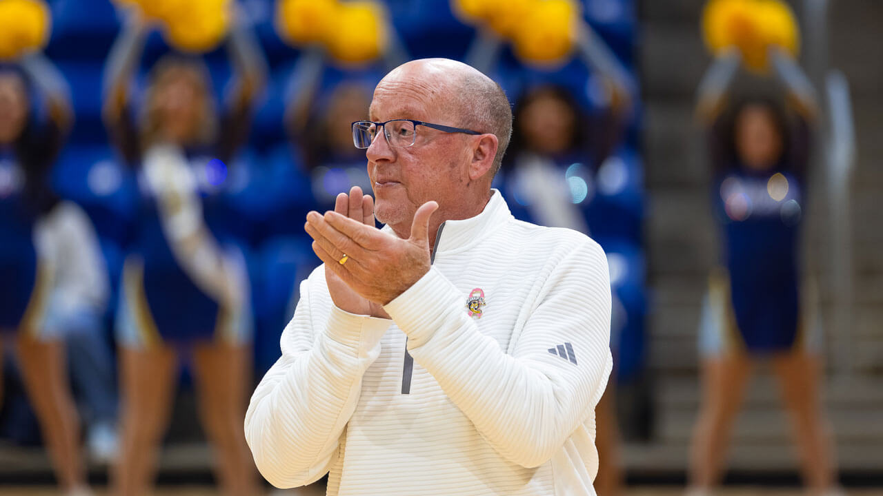 Man in Quinnipiac quarter zip clapping on the basketball court