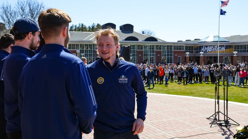 Captain of the men's ice hockey teamZach Metsa shakes hands with another player