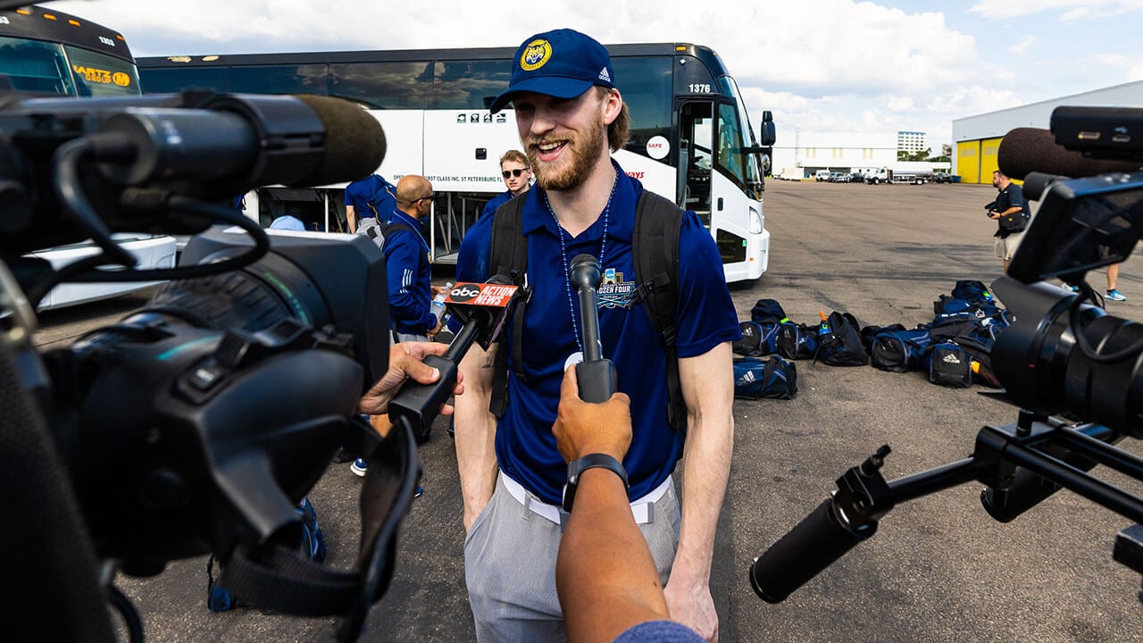 A member of the men's ice hockey team speaks with the media.