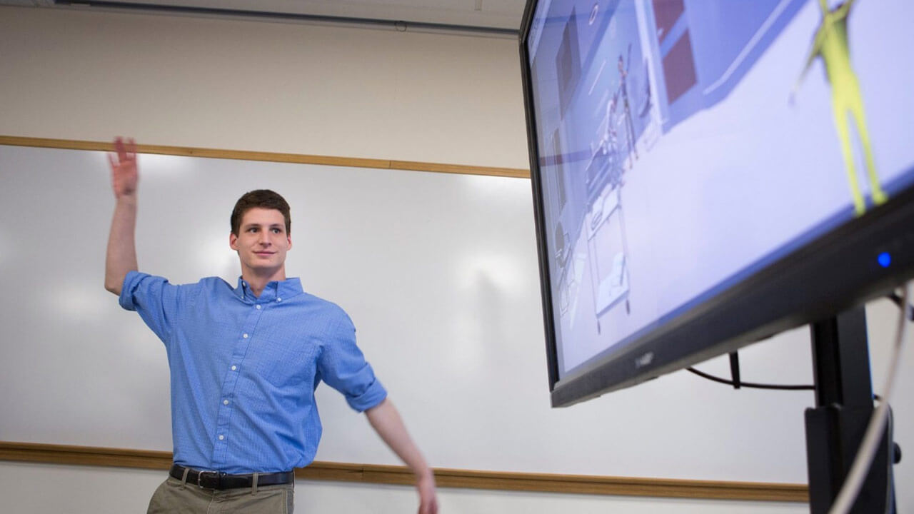 Mike Smizaski '17, a biomedical science major, demonstrates his work during an interprofessional event at the Center for Medicine, Nursing and Health Sciences on our North Haven Campus