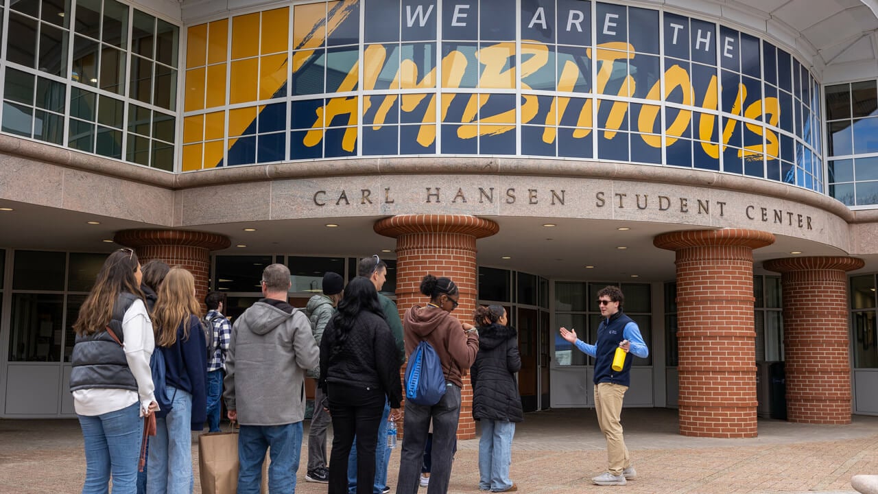 A student leads a tour group into the Carl Hansen Student Center