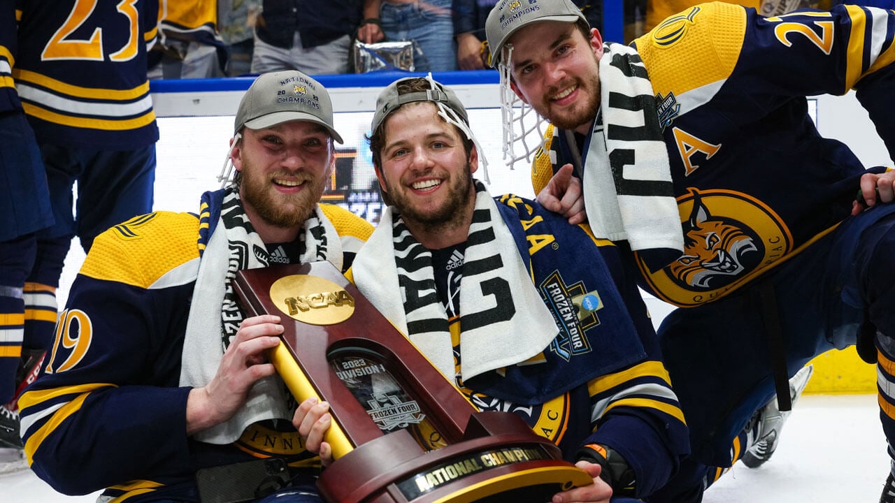 Hockey team holding trophy and smiling