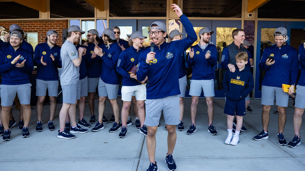 Teammate holding microphone and giving a speech