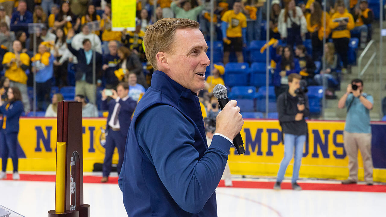 Quinnipiac mens ice hockey coach Rand Pecknold speaking to pep rally crowd