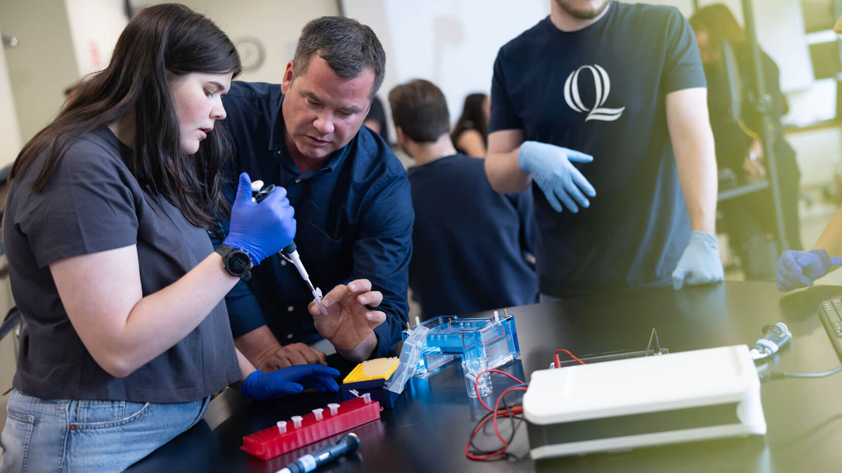 A biology professor directs a student during a lab experiment.