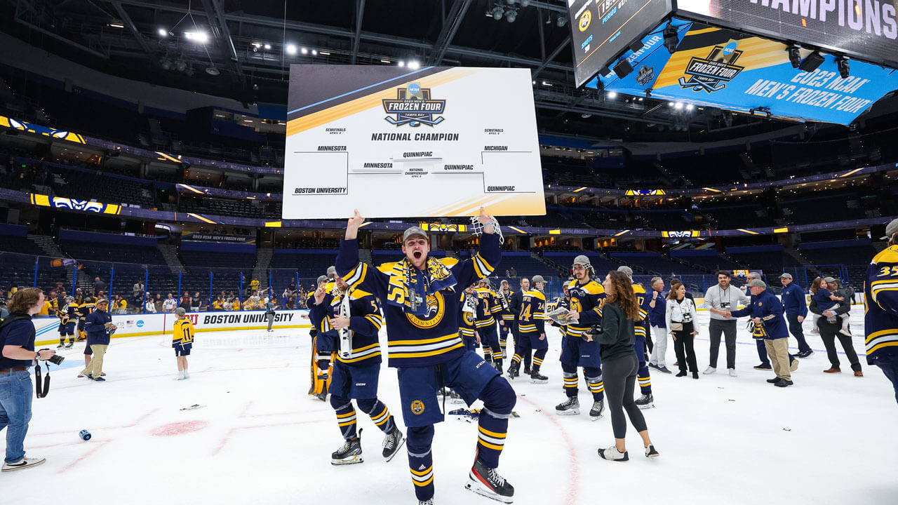 Quinnipiac ice hockey team celebrates holding NCAA championship poster