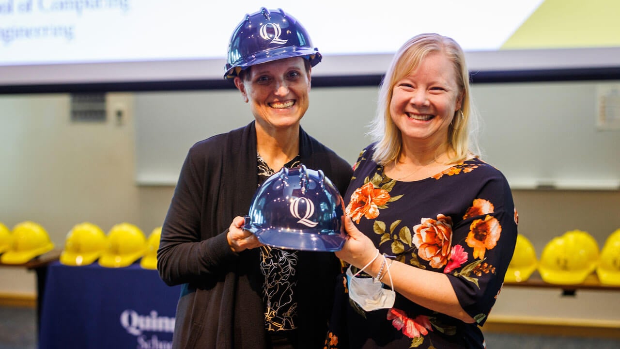 Engineer professors holding navy blue hard hat