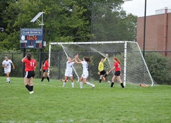 Quinnipiac soccer players high-fiving after scoring a goal