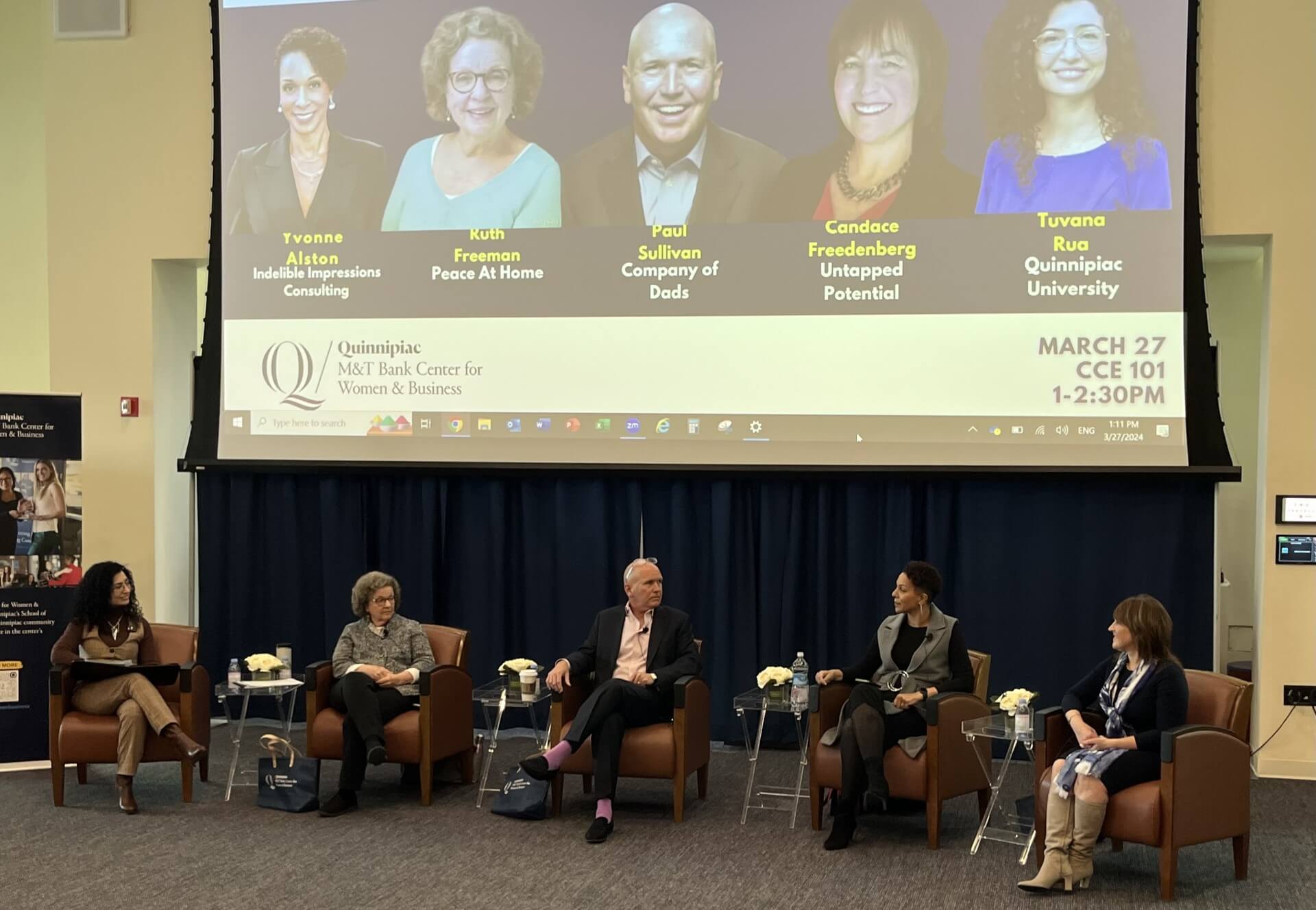 Business professionals speak on a panel in the Mount Carmel auditorium