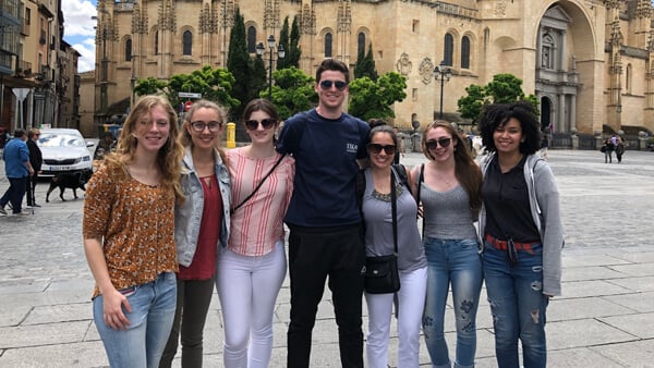 Students posing for group photo in front of a building in Spain