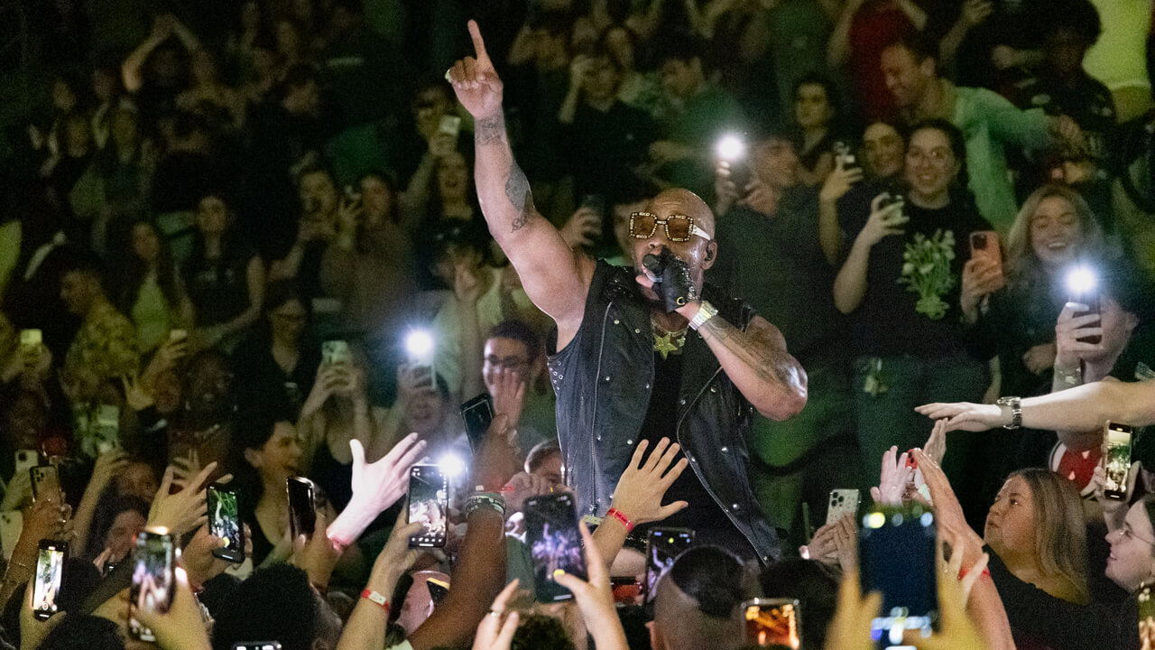 Flo Rida signs in the crowd surrounded by Quinnipiac students