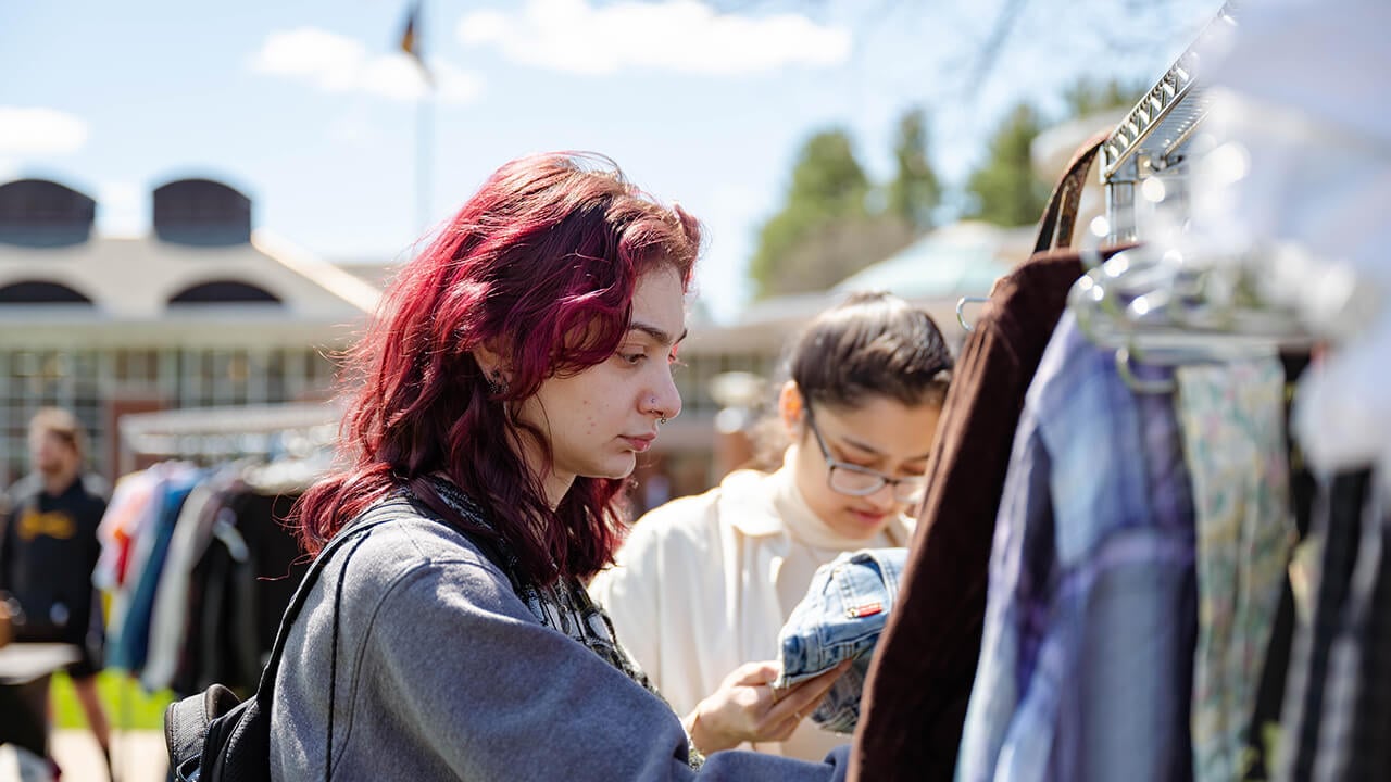 A student looks through clothing.