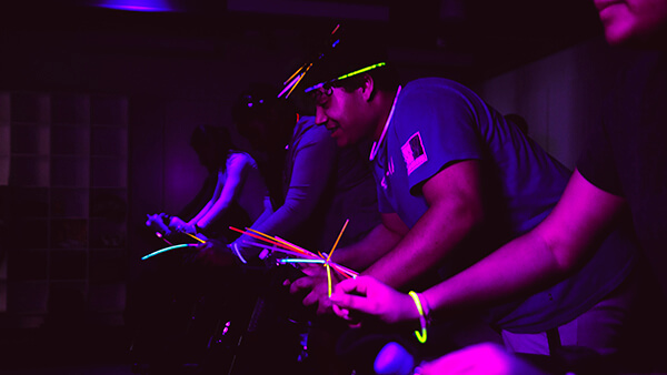 Students participating in a glow-in-the-dark spin workout class