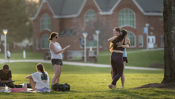 Students embracing and walking along the Quad