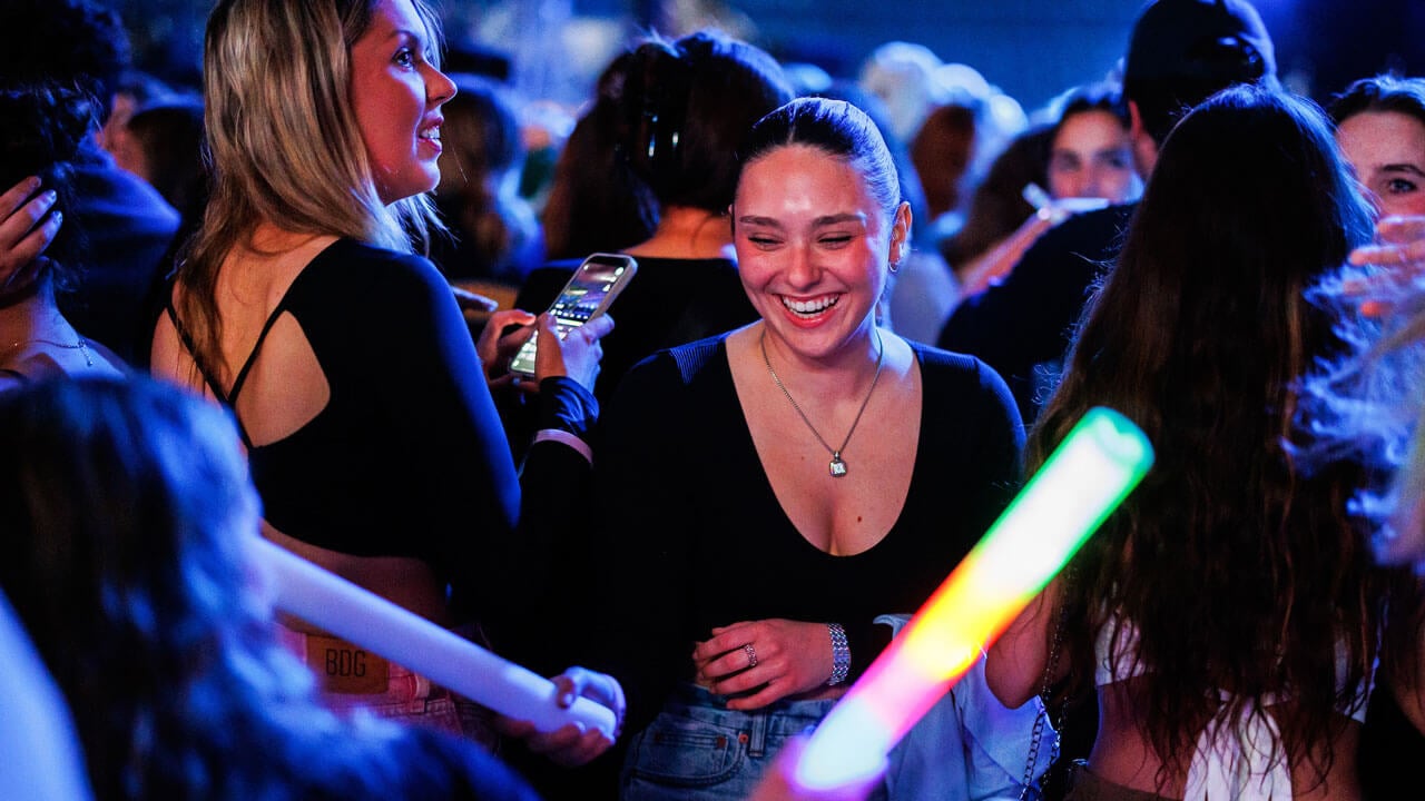 A student smiles and laughs in the crowd at Wake The Giant during Offset's performance