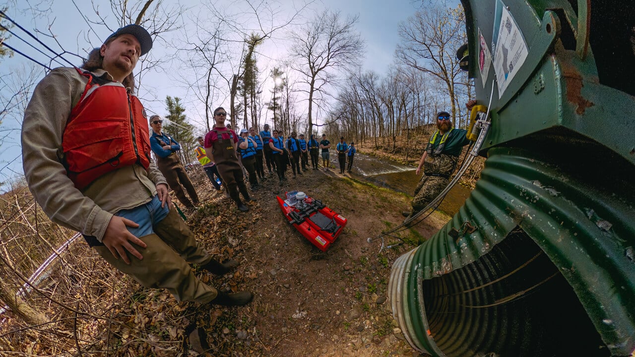 Civil engineering students measure streamflow with the USGS at the Mill River.