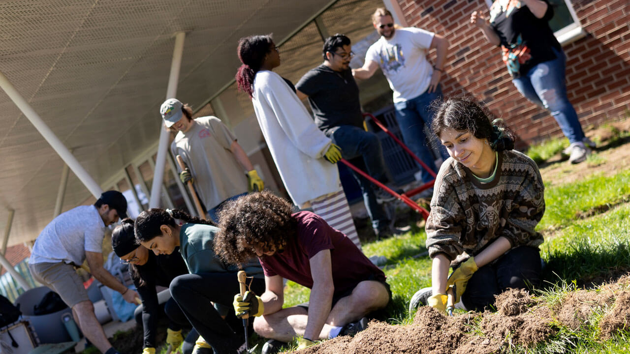 Students outside using gardening tools