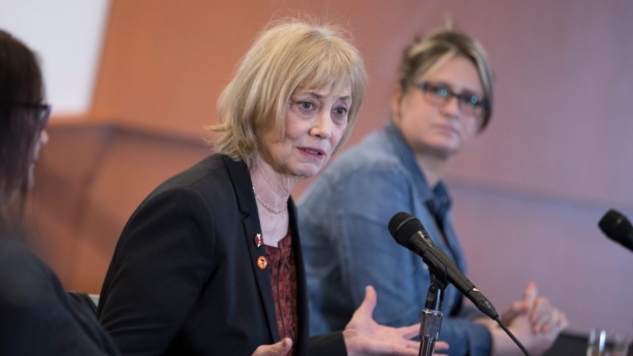 Soto sits behind a microphone at a table during a panel discussion.