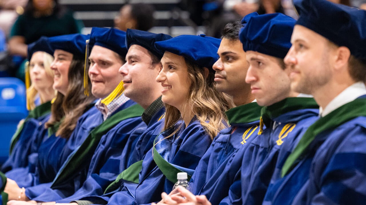 Graduates look at the stage from their seats.