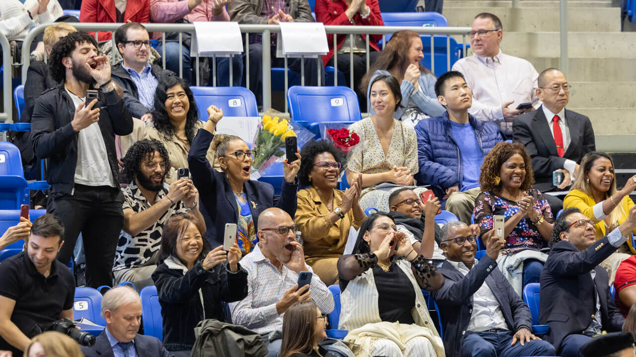 Families in the crowd cheering for the graduates