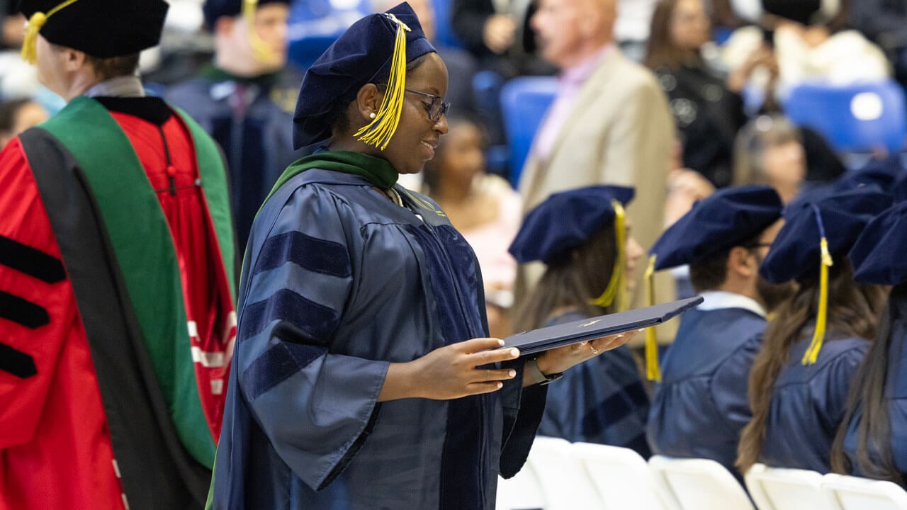 Medicine graduate carrying her degree while smiling