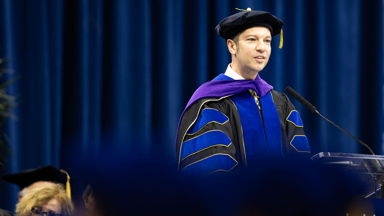 Dean Brian Gallini addresses graduates from the stage.