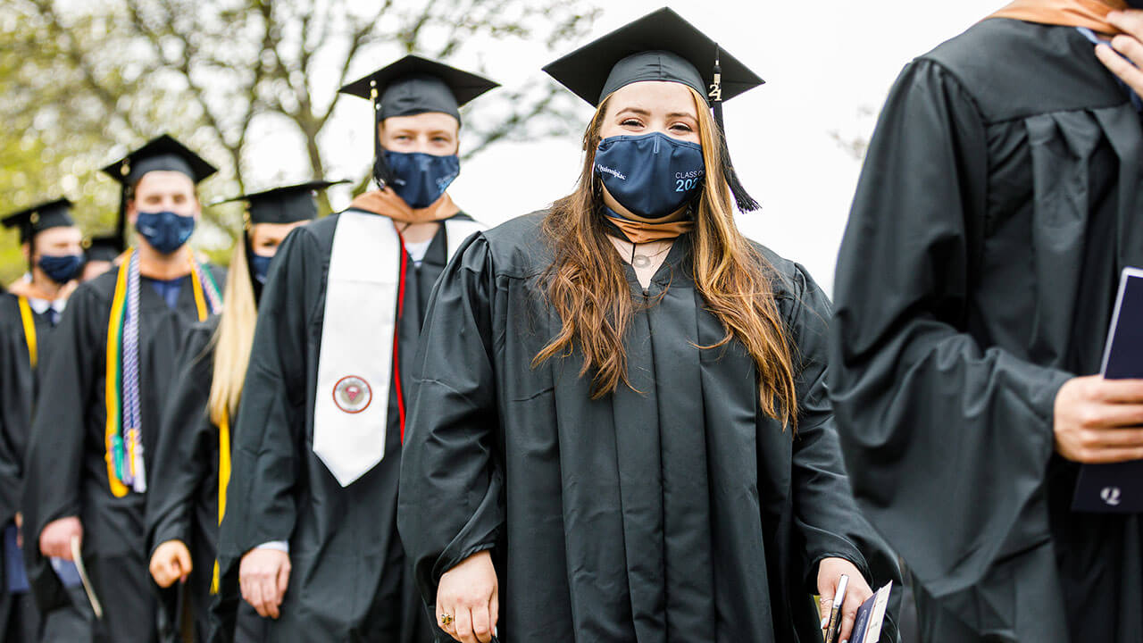 Students smiling at camera while in line for commencement