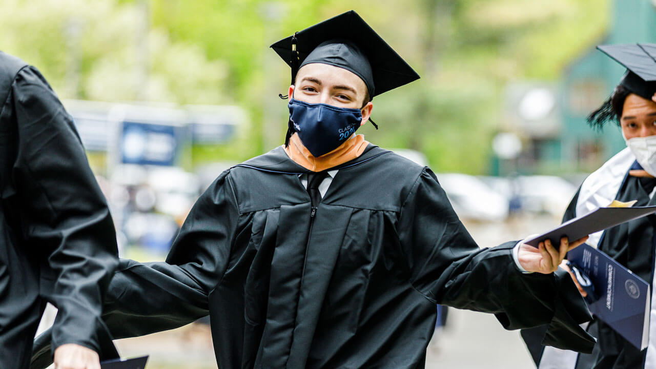 student holding diploma and smiling
