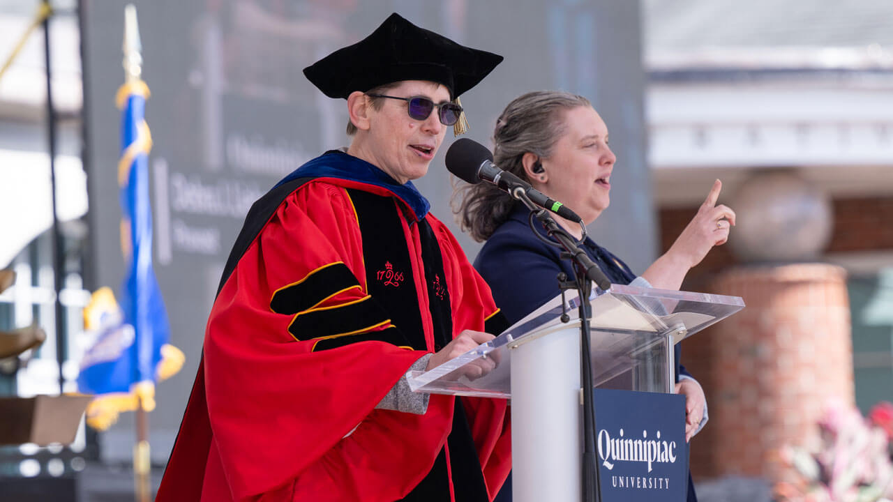 Provost Deb Liebowitz addresses graduates and guests from a podium.