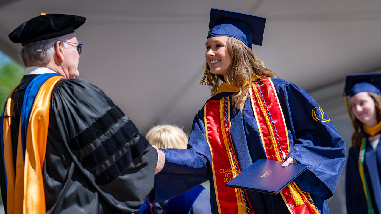 A grad receiving their diploma on stage