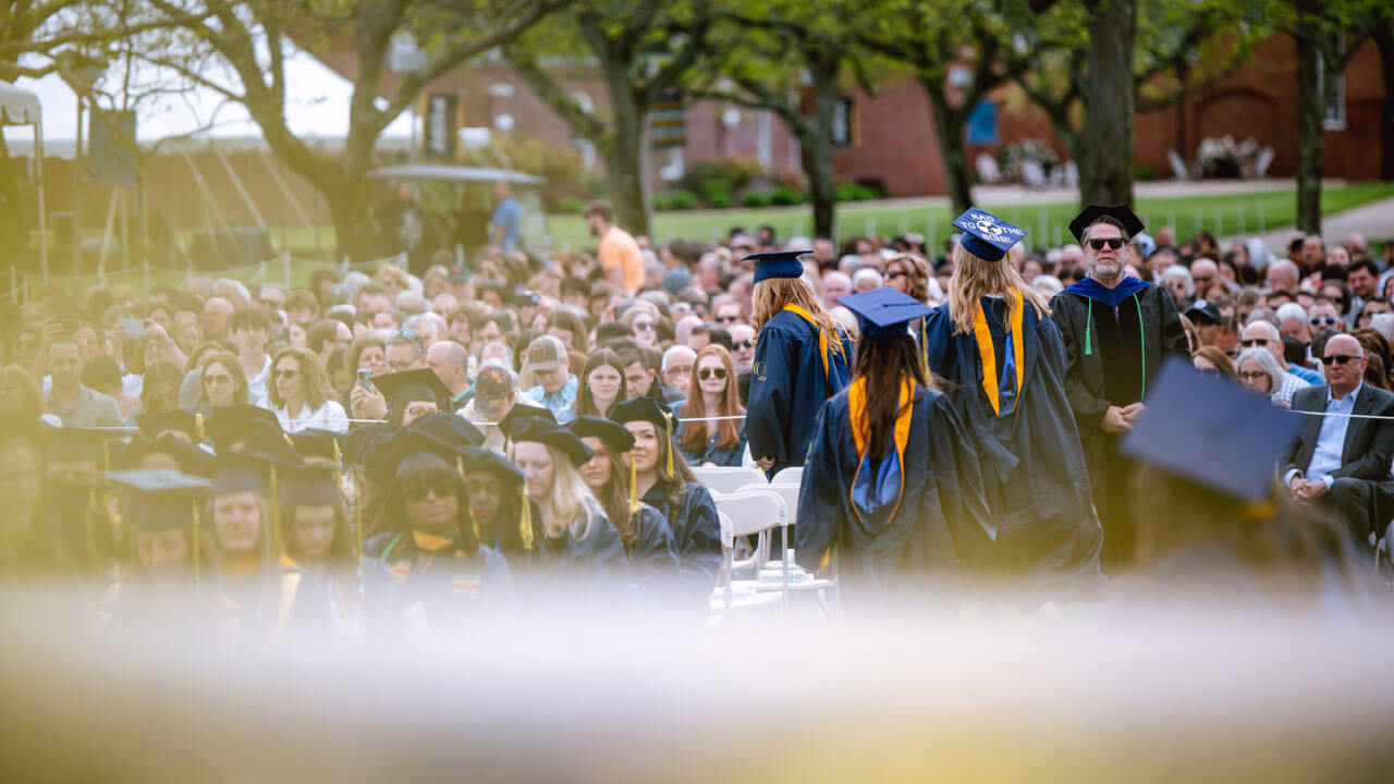 Three Health Sciences graduates make their way to their seats as the Commencement ceremony begins.