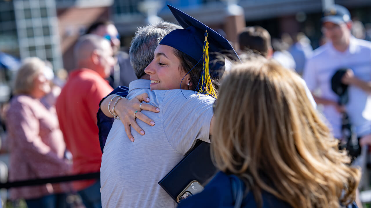 A graduate gives a loved one a big hug