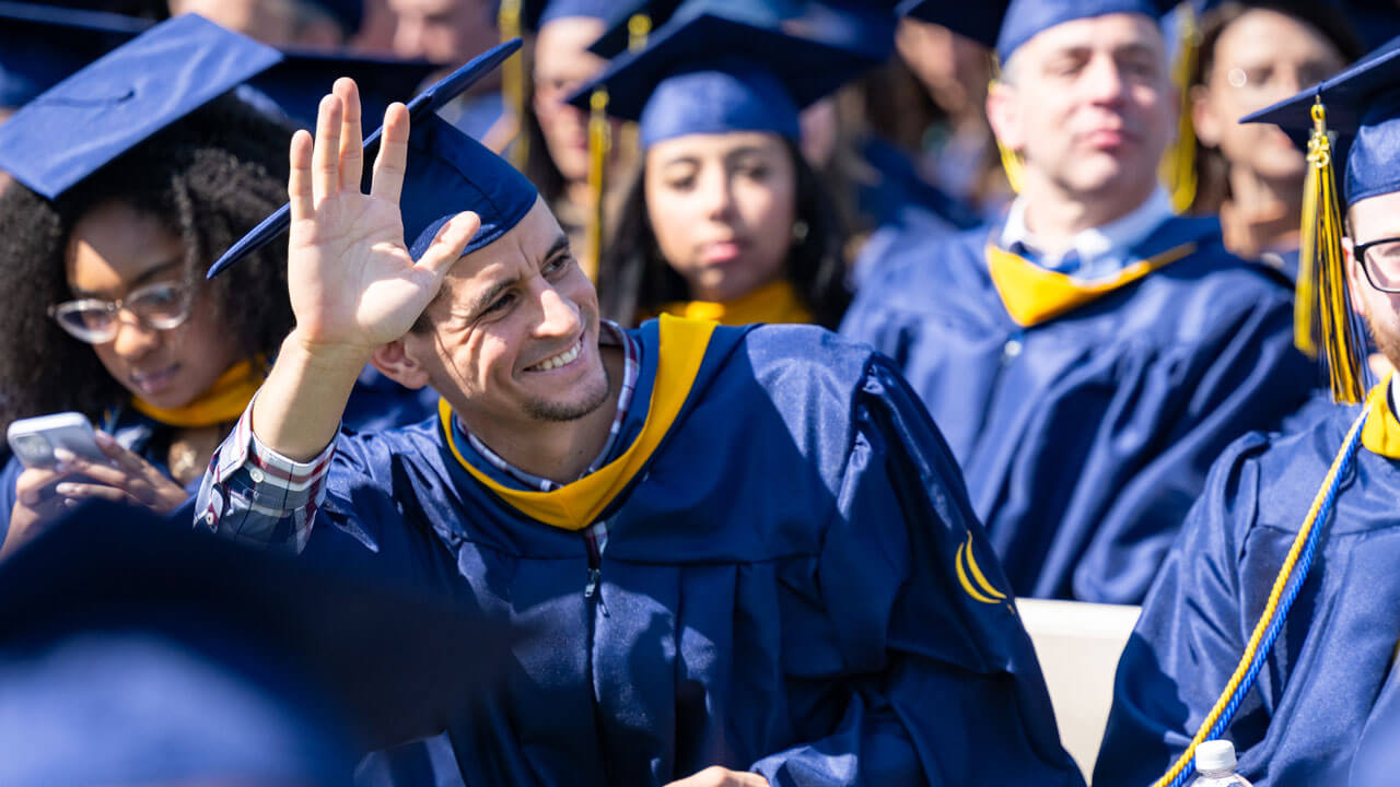 Graduate waves in the crowd.