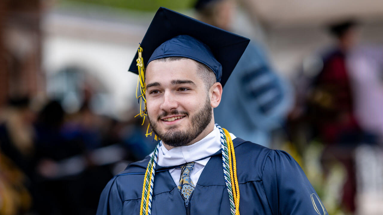 SOC graduate smiling and walking down the precession