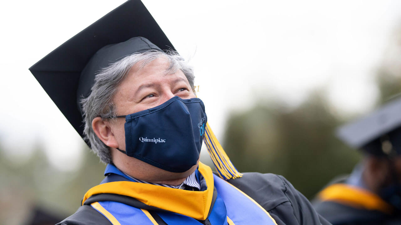 A graduate proudly stands during the Commencement ceremony