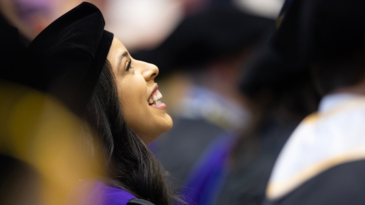 Graduate smiles up at their family