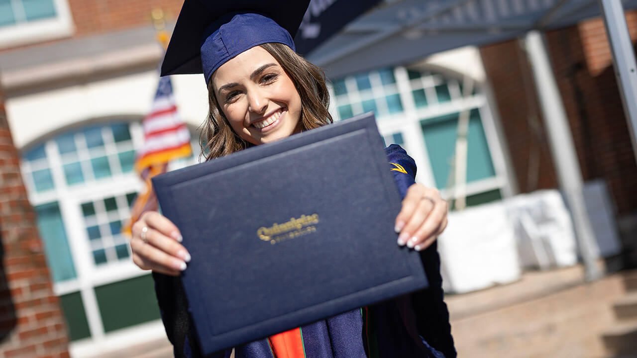 graduate poses with new diploma