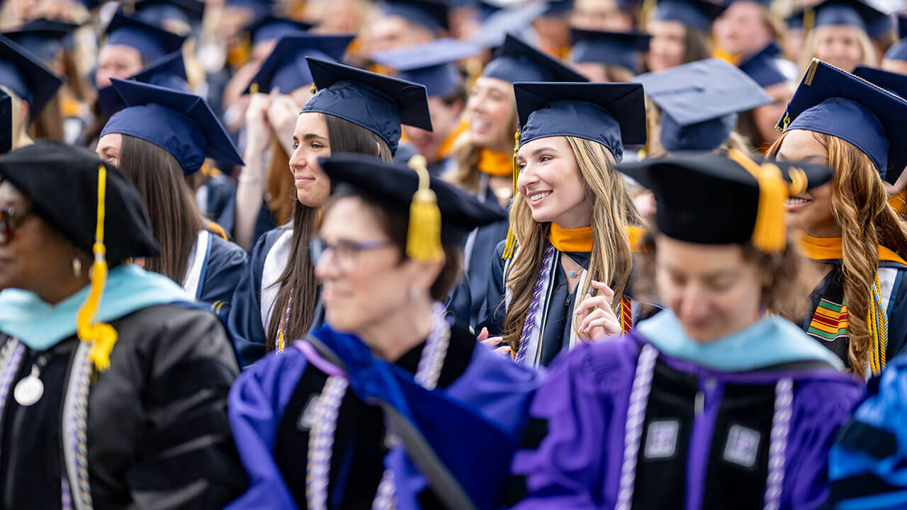 graduates sit smiling