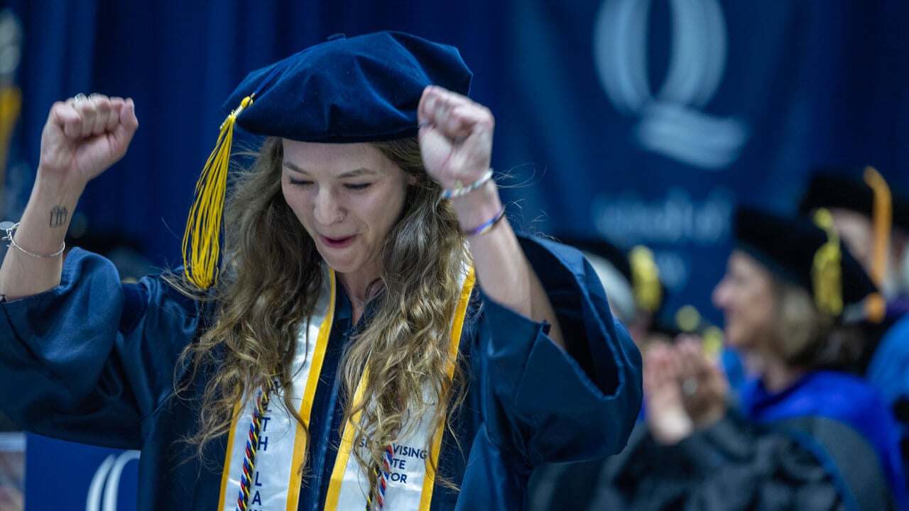 School of Law graduate cheers as she walks off the stage