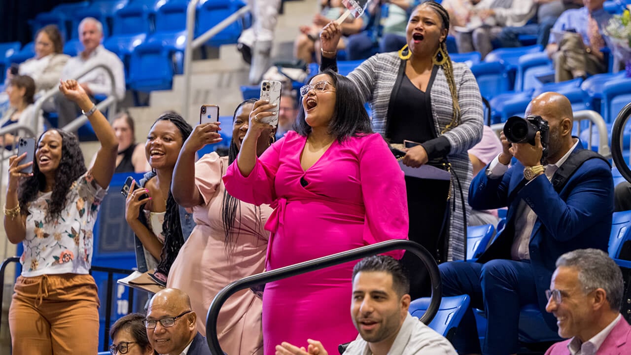 Family members cheer and record graduates