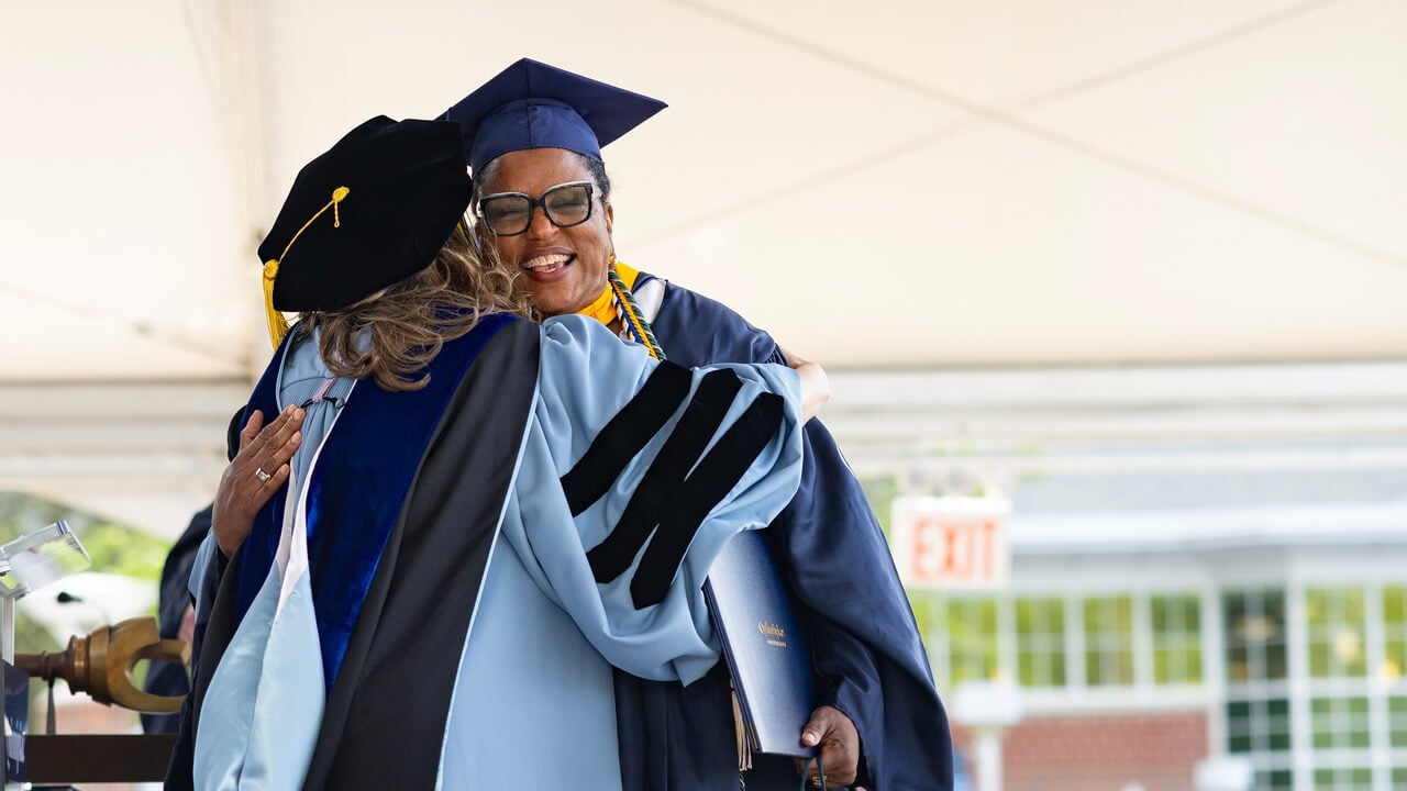 Student hugs individual