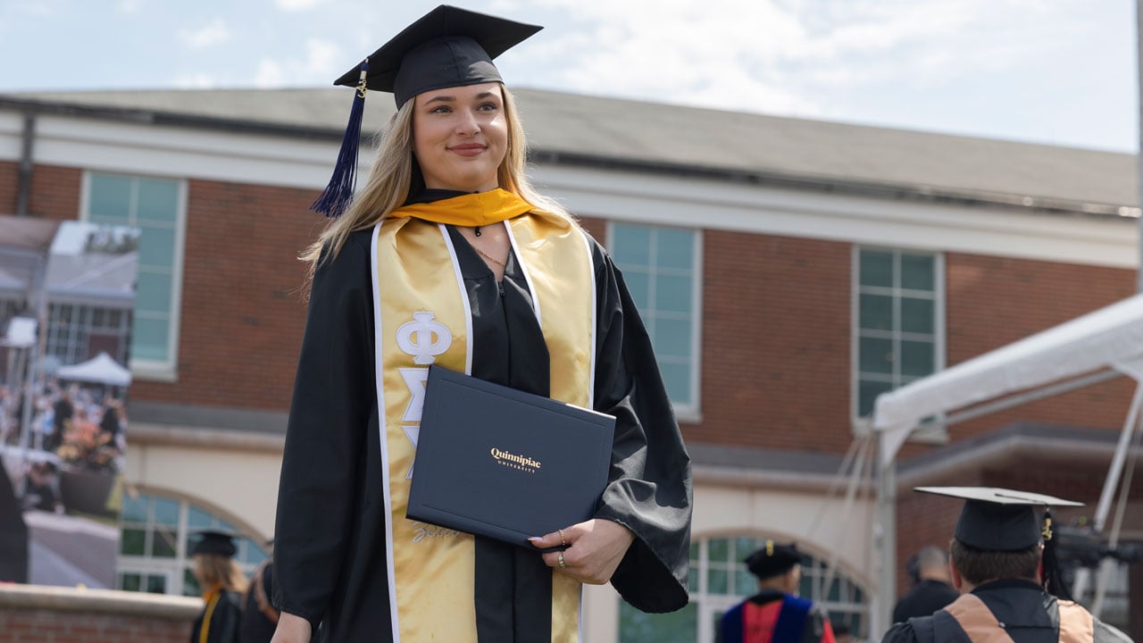 SOB graduate holds up diploma