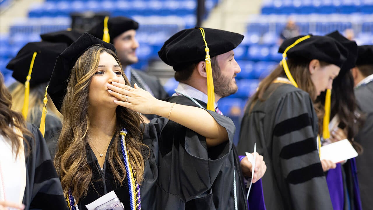 Law grad student blowing a kiss to the crowd