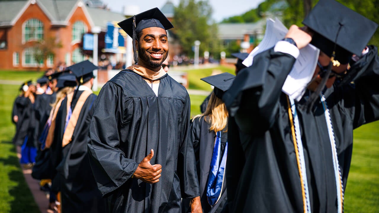 Graduates walk down the Quad during Commencement